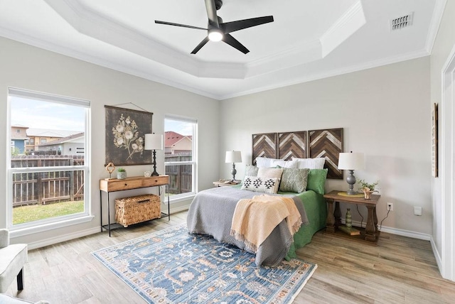 5810 Bella Di Giorno Dr, Corpus Christi, TX 78414 - bedroom with a tray ceiling, crown molding, wood finished floors, multiple windows, and a ceiling fan