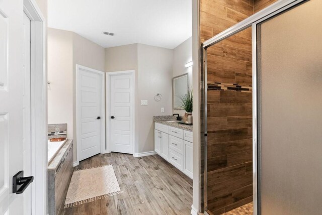 5810 Bella Di Giorno Dr, Corpus Christi, TX 78414 - full bath with vanity, a stall shower, a bath, and wood finished floors
