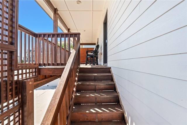 stairway featuring wooden walls