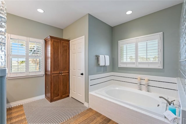 bathroom with tile patterned flooring and tiled tub