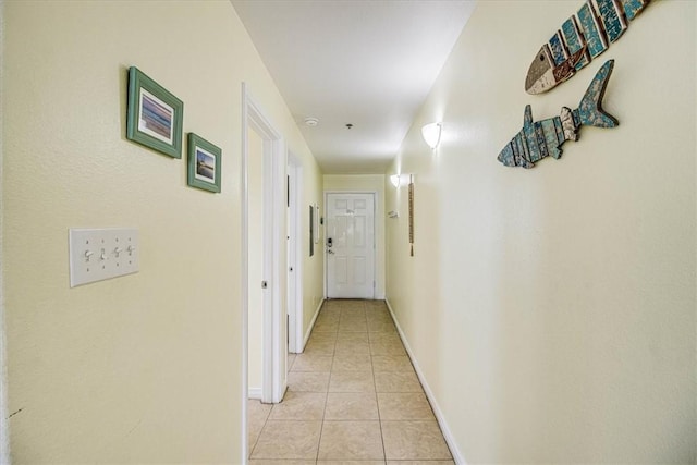 hallway featuring light tile patterned floors and baseboards