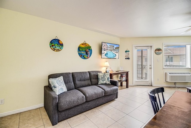 living room featuring light tile patterned flooring, baseboards, an AC wall unit, and a ceiling fan