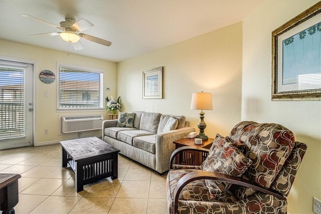 living area with light tile patterned floors, baseboards, a wall mounted air conditioner, and a ceiling fan