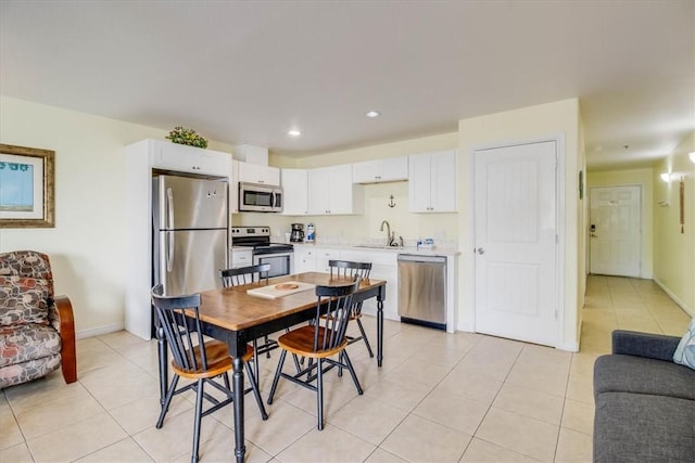 kitchen featuring a sink, stainless steel appliances, white cabinets, and light countertops