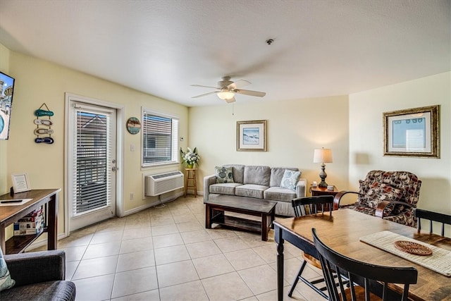 living area featuring light tile patterned floors, baseboards, a wall mounted AC, and ceiling fan