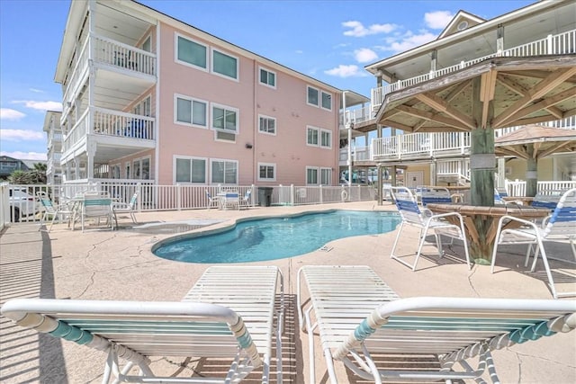 pool with a patio and fence