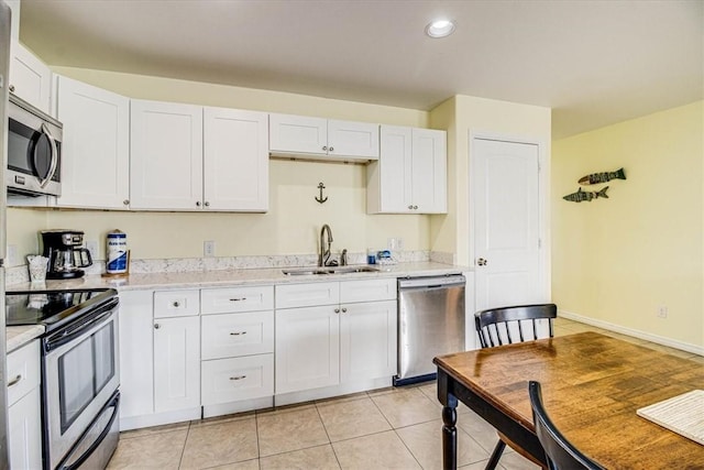 kitchen featuring white cabinets, appliances with stainless steel finishes, light countertops, and a sink