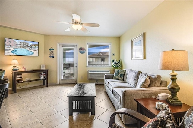 living room with light tile patterned flooring, ceiling fan, baseboards, and a wall unit AC