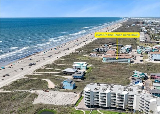 birds eye view of property featuring a beach view and a water view