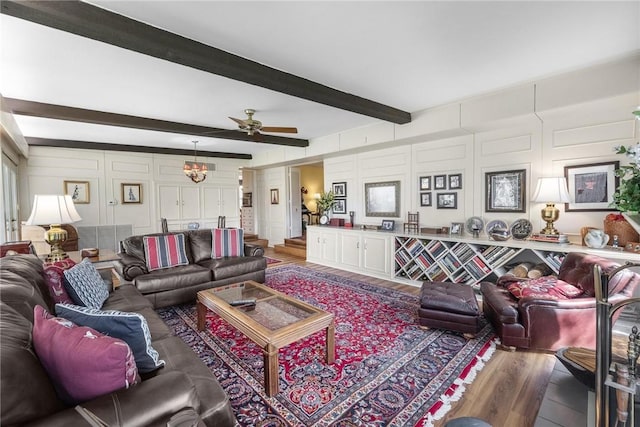 living room with light wood-style floors, a decorative wall, beamed ceiling, and ceiling fan