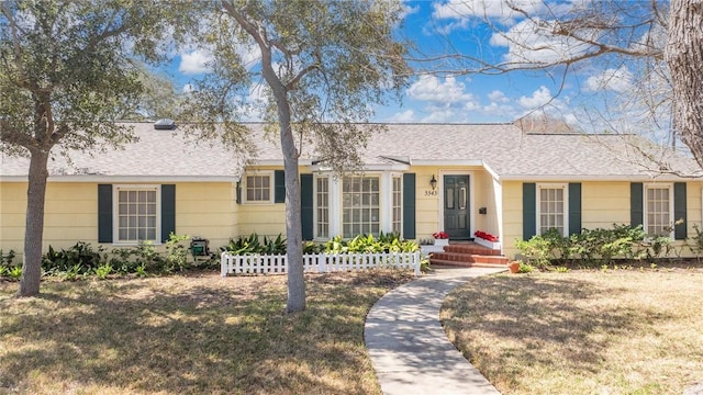 single story home featuring roof with shingles and a front lawn