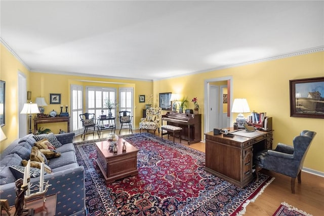 living room with baseboards, wood finished floors, and crown molding