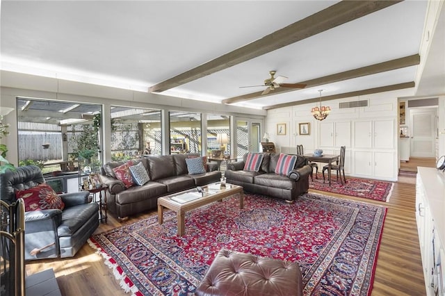 living room featuring a ceiling fan, visible vents, beamed ceiling, and wood finished floors