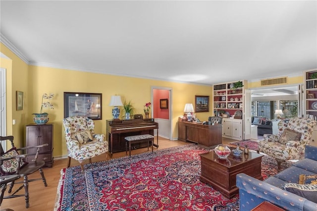 living room with visible vents, wood finished floors, and ornamental molding