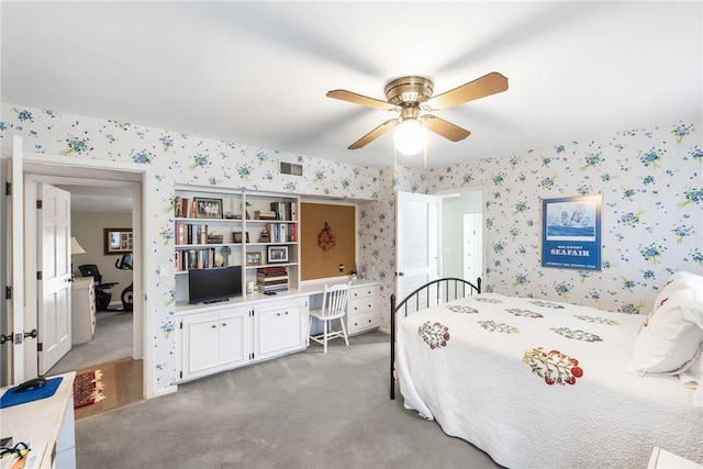 carpeted bedroom with visible vents, ceiling fan, and wallpapered walls