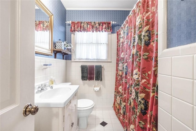 full bath featuring toilet, wainscoting, vanity, tile patterned flooring, and wallpapered walls