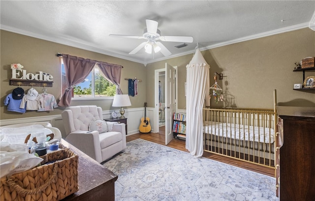 5222 Wooldridge, Corpus Christi, TX 78413 - bedroom featuring ornamental molding, wood finished floors, a wainscoted wall, a ceiling fan, and a textured ceiling