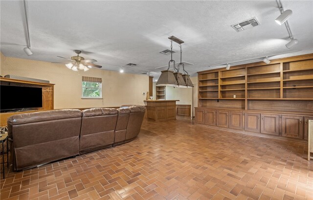 5222 Wooldridge, Corpus Christi, TX 78413 - living area featuring rail lighting, ceiling fan, brick patterned flooring, and a textured ceiling