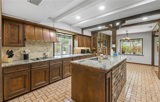 5222 Wooldridge, Corpus Christi, TX 78413 - kitchen featuring black electric stovetop, brick flooring, backsplash, beamed ceiling, and light stone countertops
