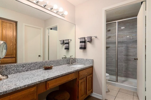 bathroom featuring walk in shower, tile patterned flooring, vanity, and toilet