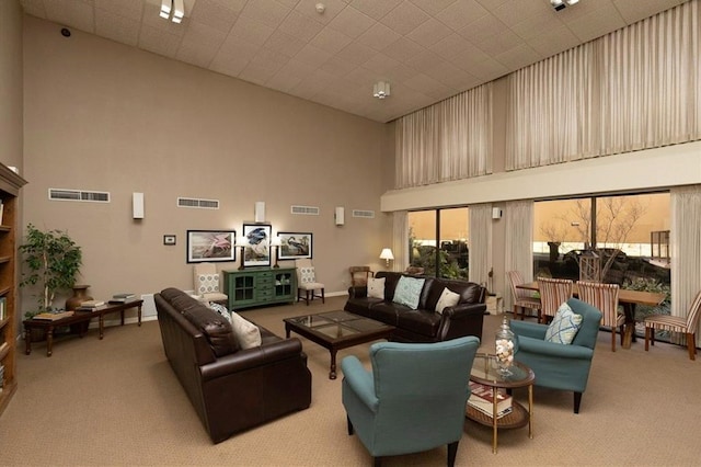 living room with a high ceiling and light colored carpet