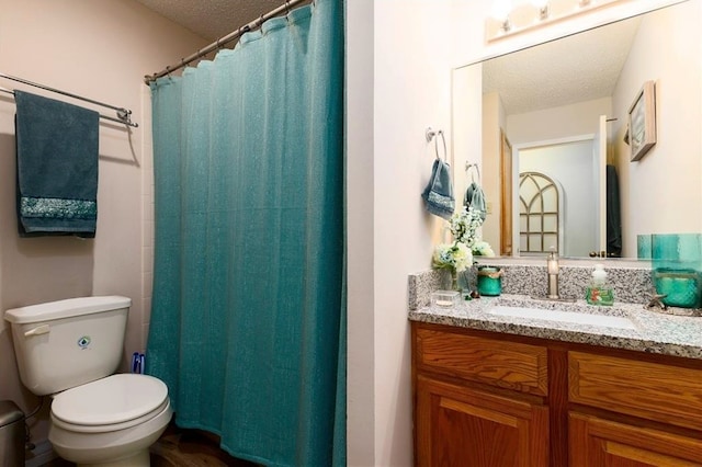 bathroom featuring curtained shower, vanity, a textured ceiling, and toilet