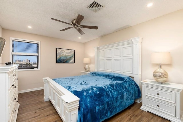 bedroom featuring a textured ceiling, ceiling fan, and dark wood-type flooring