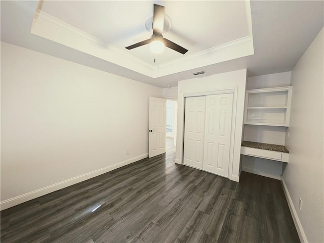 4010 Moorhead Dr, Corpus Christi, TX 78410 - unfurnished bedroom featuring a tray ceiling, dark wood-type flooring, a closet, ornamental molding, and ceiling fan