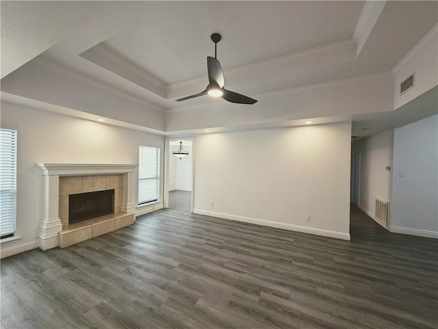 4010 Moorhead Dr, Corpus Christi, TX 78410 - unfurnished living room featuring a tray ceiling, crown molding, ceiling fan, dark wood-style flooring, and a fireplace
