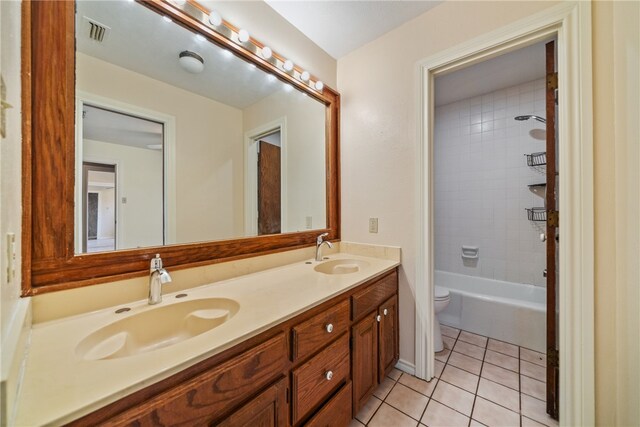 full bathroom with toilet, tiled shower / bath combo, vanity, and tile patterned floors