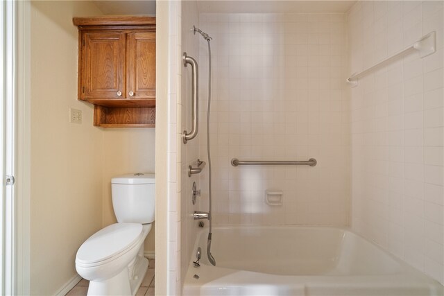 bathroom featuring tile patterned floors, tiled shower / bath, and toilet