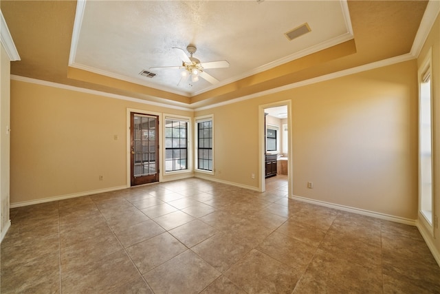 empty room featuring ornamental molding, ceiling fan, and a raised ceiling