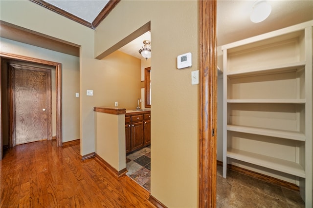 hall with crown molding, sink, and dark hardwood / wood-style flooring