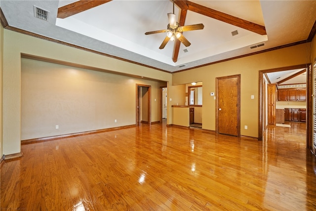 spare room with ceiling fan, a tray ceiling, light hardwood / wood-style flooring, and ornamental molding