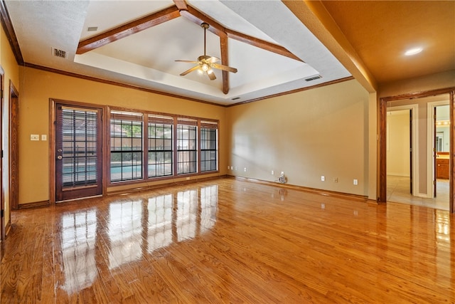 unfurnished living room featuring ceiling fan, beam ceiling, a raised ceiling, and light hardwood / wood-style flooring