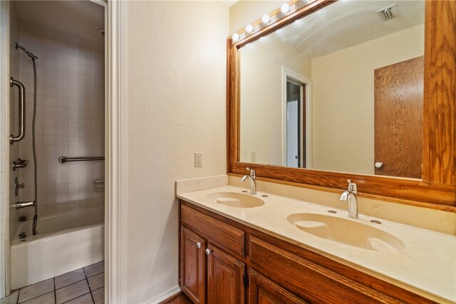 bathroom featuring vanity, tile patterned flooring, and tiled shower / bath