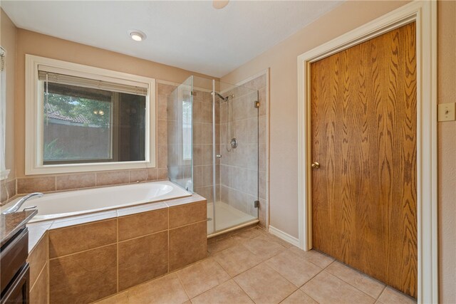 bathroom featuring tile patterned floors and separate shower and tub