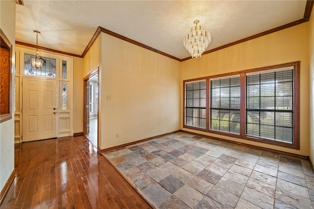 foyer entrance featuring ornamental molding, a wealth of natural light, a notable chandelier, and dark hardwood / wood-style floors