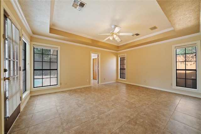 tiled empty room featuring ceiling fan, a raised ceiling, and crown molding