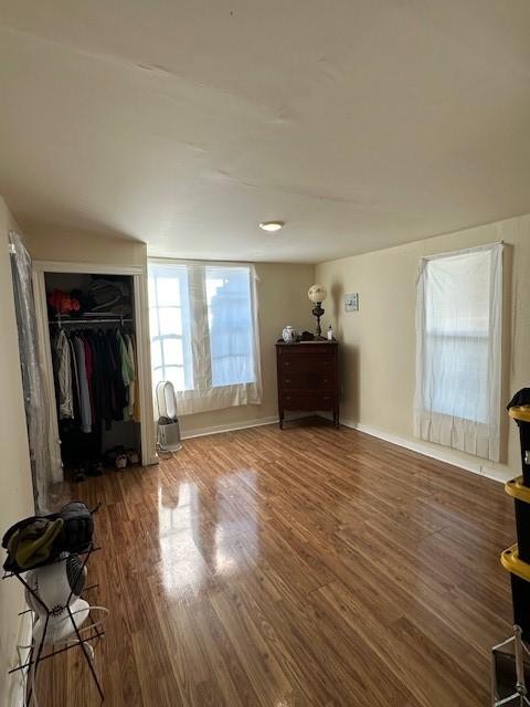 unfurnished bedroom with dark wood-type flooring and a closet