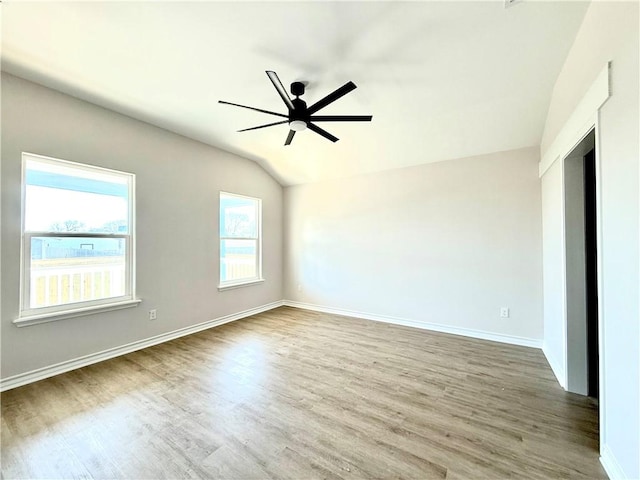 unfurnished room featuring baseboards, vaulted ceiling, a ceiling fan, and wood finished floors