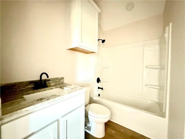 bathroom with toilet, washtub / shower combination, wood finished floors, and vanity