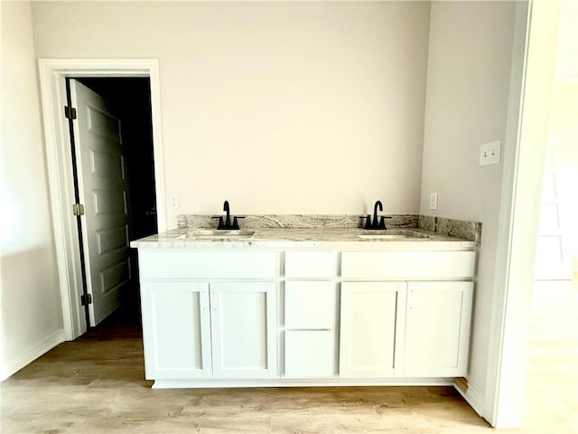 bathroom with a sink and wood finished floors