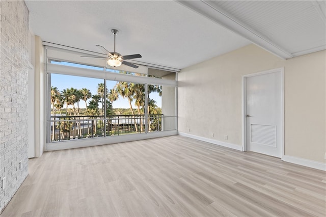 interior space featuring ceiling fan, light hardwood / wood-style floors, and beamed ceiling