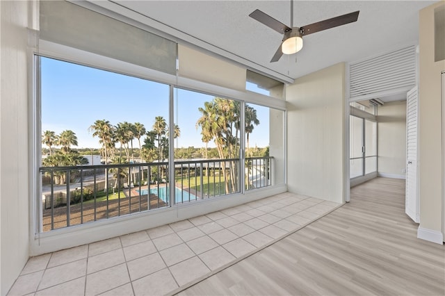 unfurnished room with ceiling fan, a wealth of natural light, and light hardwood / wood-style floors