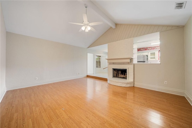 unfurnished living room with vaulted ceiling with beams, visible vents, light wood-style floors, a ceiling fan, and a brick fireplace