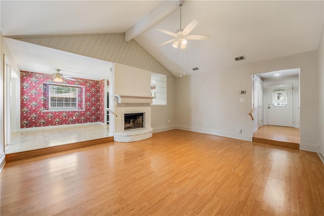 unfurnished living room with a ceiling fan, light wood finished floors, baseboards, a brick fireplace, and visible vents