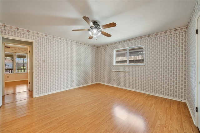 empty room featuring light wood-type flooring, baseboards, and ceiling fan