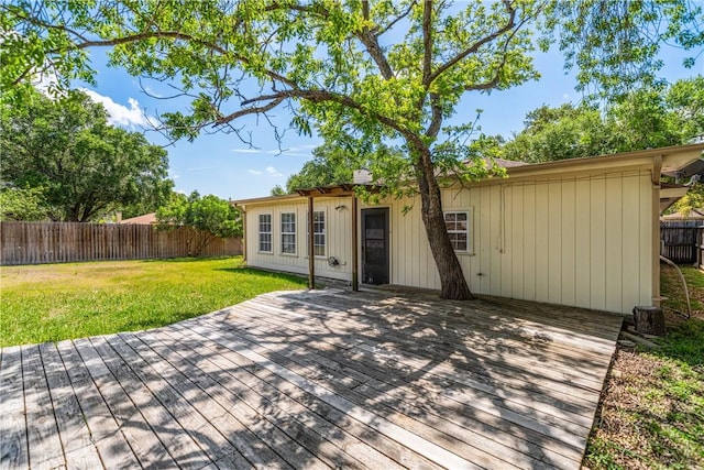 rear view of property featuring a yard, a fenced backyard, and a deck