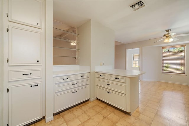 kitchen featuring a peninsula, a ceiling fan, visible vents, and light countertops